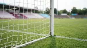 Fußballtor und Netz am Rand eines grünen Spielfelds